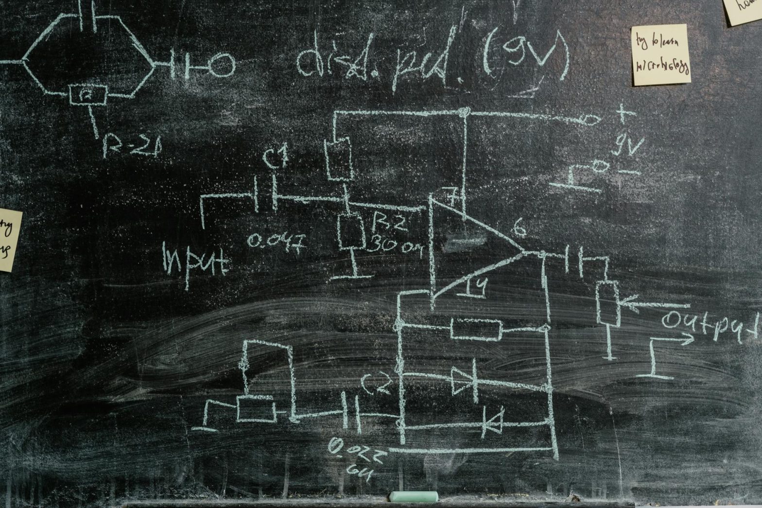 Detailed chalkboard displaying science diagrams and sticky notes, showcasing scientific exploration.
