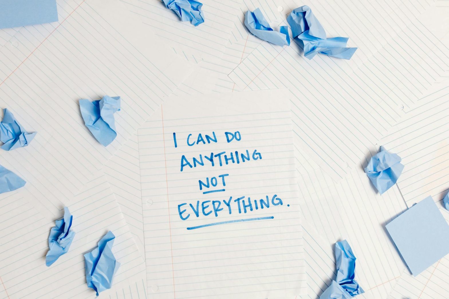Inspirational message on a notepad surrounded by crumpled paper pieces.
